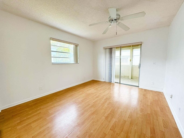 empty room with a textured ceiling, light hardwood / wood-style floors, and ceiling fan