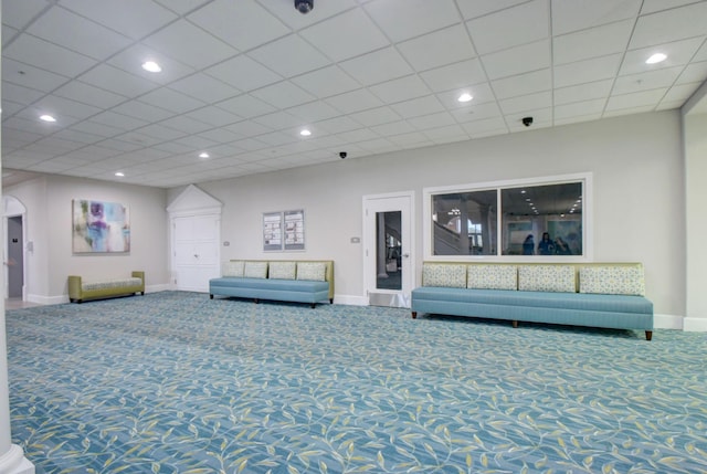 unfurnished living room featuring a paneled ceiling and carpet floors