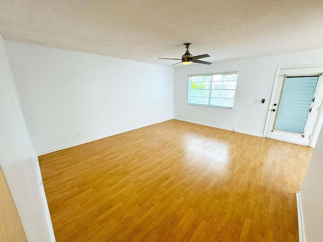 spare room with ceiling fan, wood-type flooring, and a textured ceiling