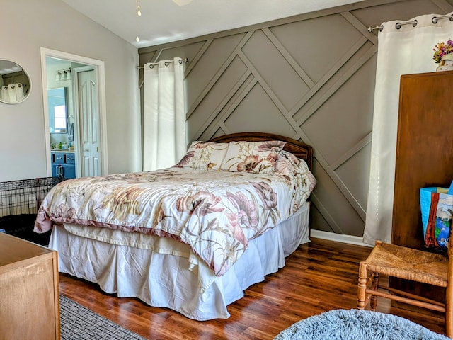 bedroom with ensuite bath, lofted ceiling, and dark hardwood / wood-style floors