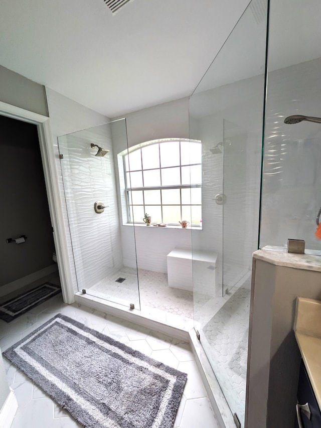 bathroom with tiled shower, tile patterned floors, and vanity