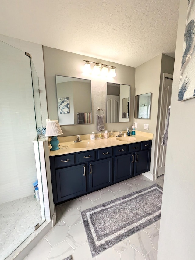 bathroom featuring vanity, a textured ceiling, and tiled shower