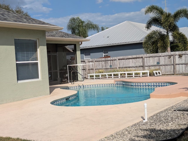 view of swimming pool with a patio area and a sunroom