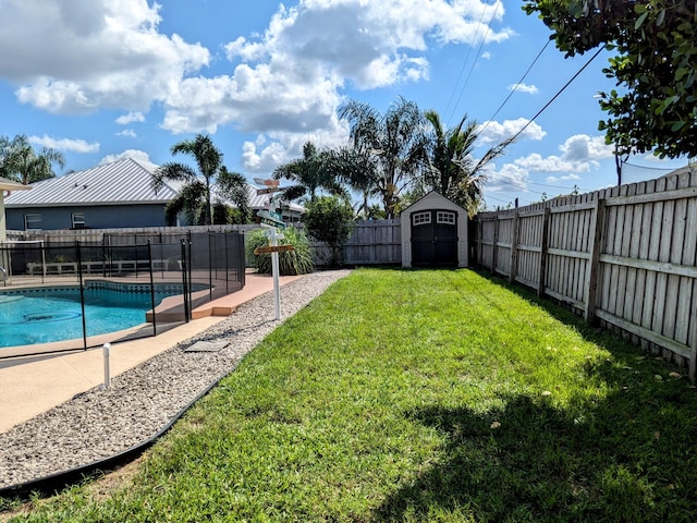 view of yard featuring a fenced in pool and a shed