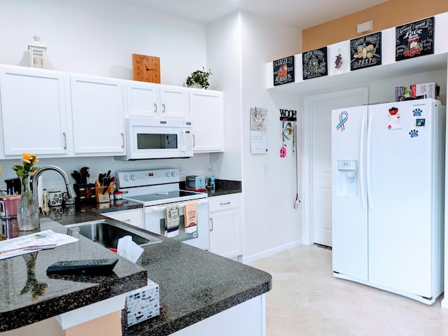 kitchen featuring light tile patterned flooring, sink, dark stone countertops, white appliances, and white cabinets