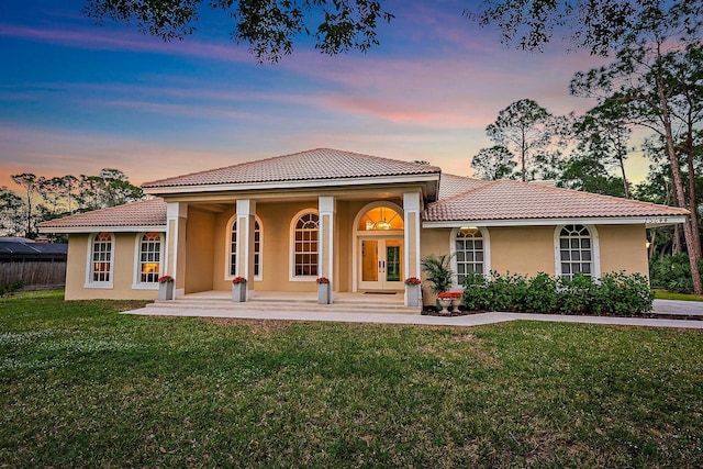 view of front of home featuring a yard and french doors