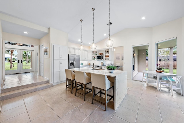 kitchen featuring white cabinets, light tile patterned floors, stainless steel appliances, and vaulted ceiling