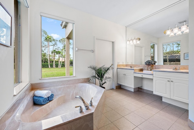 bathroom featuring tile patterned floors, tiled bath, vanity, and a healthy amount of sunlight