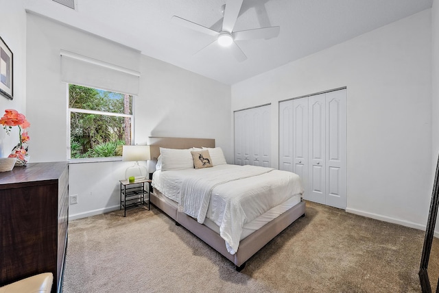 carpeted bedroom with multiple closets and ceiling fan