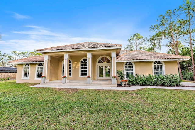 back of house with a lawn and french doors