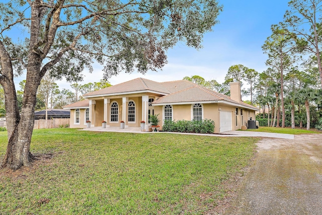 view of front of property featuring a garage, central air condition unit, and a front lawn