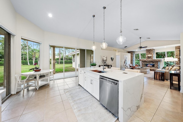 kitchen with sink, stainless steel dishwasher, an island with sink, light stone counters, and white cabinetry