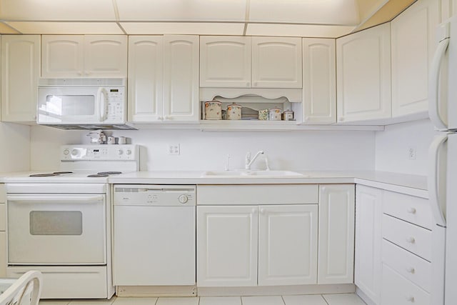 kitchen featuring sink, white cabinets, white appliances, and light tile patterned floors