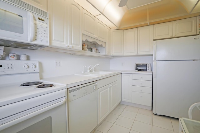 kitchen featuring sink, white cabinets, light tile patterned flooring, and white appliances