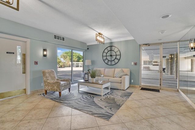 living room with a textured ceiling, light tile patterned floors, and ornamental molding