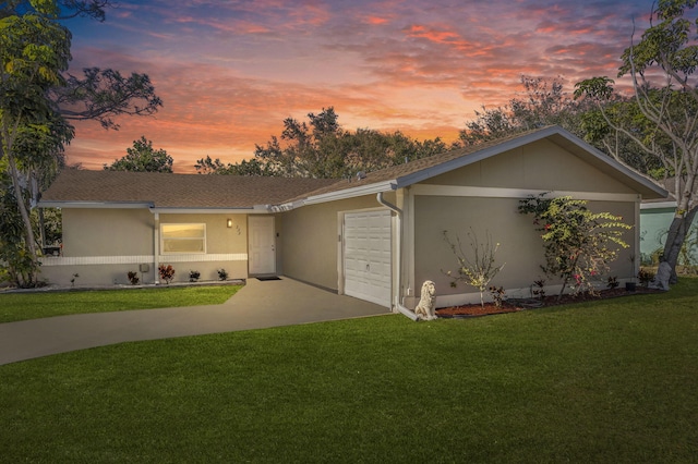 ranch-style house featuring a yard and a garage