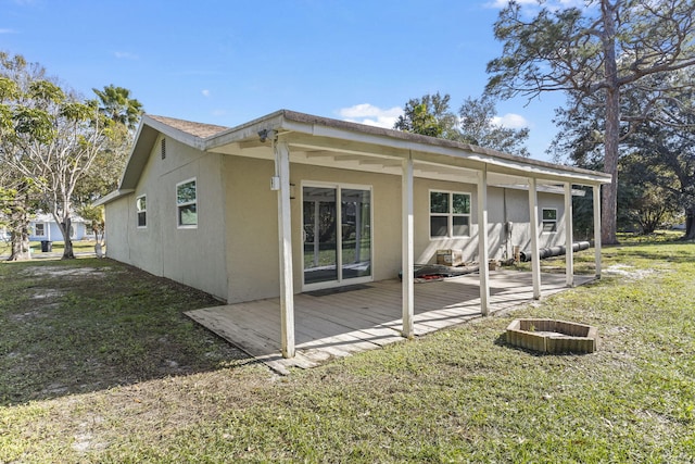 rear view of house with a yard and a wooden deck