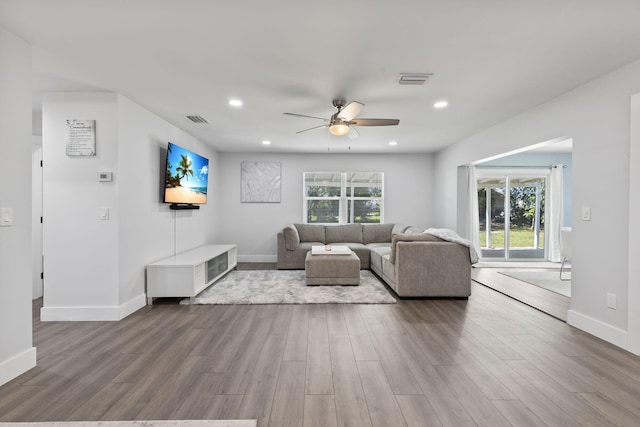 living room featuring wood-type flooring and ceiling fan