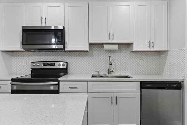 kitchen with decorative backsplash, appliances with stainless steel finishes, white cabinetry, and sink