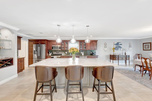 kitchen featuring a breakfast bar area, appliances with stainless steel finishes, a large island, tasteful backsplash, and glass insert cabinets