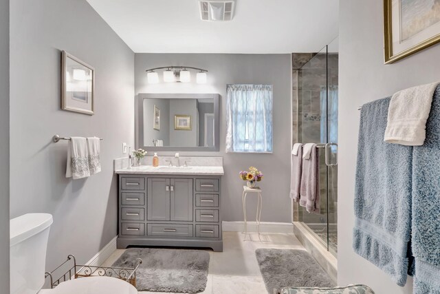 bathroom featuring a shower stall, visible vents, baseboards, and vanity