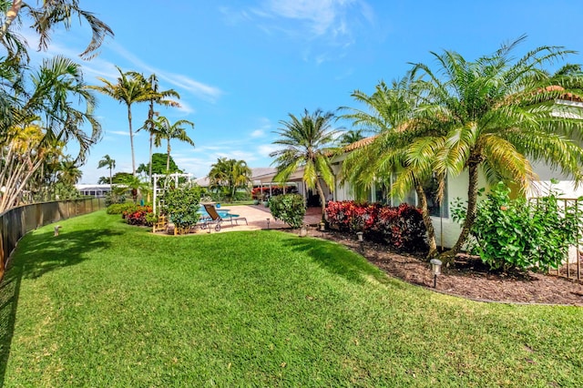 view of yard featuring a patio area, fence, and a fenced in pool