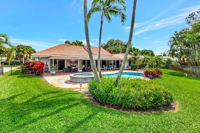 back of house with a fenced in pool, a lawn, a fenced backyard, a tile roof, and an in ground hot tub