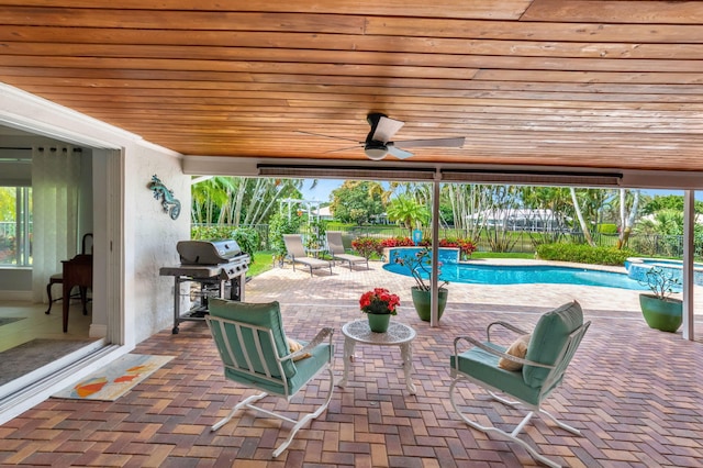 view of patio featuring area for grilling, a fenced backyard, a pool with connected hot tub, and a ceiling fan