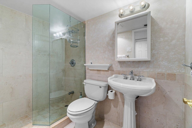 bathroom featuring tile walls, toilet, and a tile shower