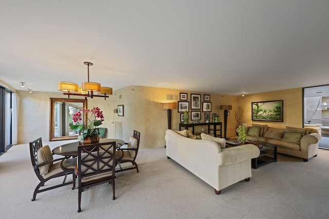 living room with light colored carpet and an inviting chandelier