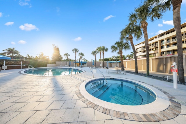 view of swimming pool featuring a hot tub and a patio area