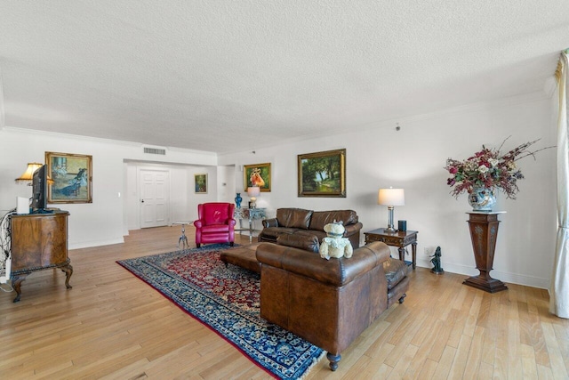 living room featuring ornamental molding, a textured ceiling, and light hardwood / wood-style floors