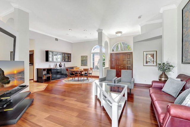 living room with hardwood / wood-style floors, ornamental molding, and ornate columns