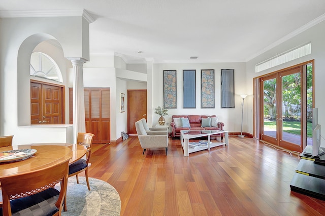 living room with french doors, ornamental molding, light wood-type flooring, and ornate columns