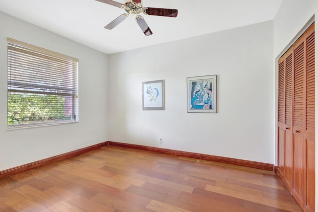 unfurnished bedroom featuring ceiling fan, wood-type flooring, and a closet