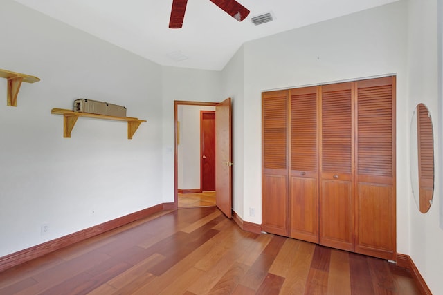 unfurnished bedroom featuring ceiling fan, wood-type flooring, and a closet