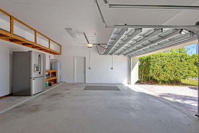 garage with water heater, a garage door opener, and stainless steel fridge