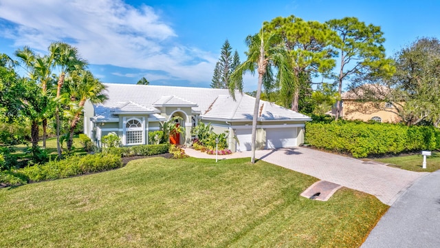 ranch-style home featuring a garage and a front lawn