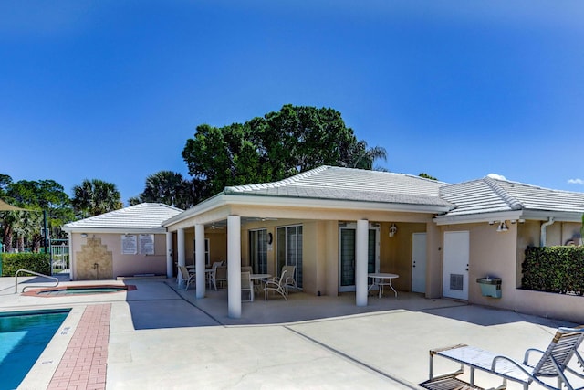 back of house featuring a community pool and a patio area