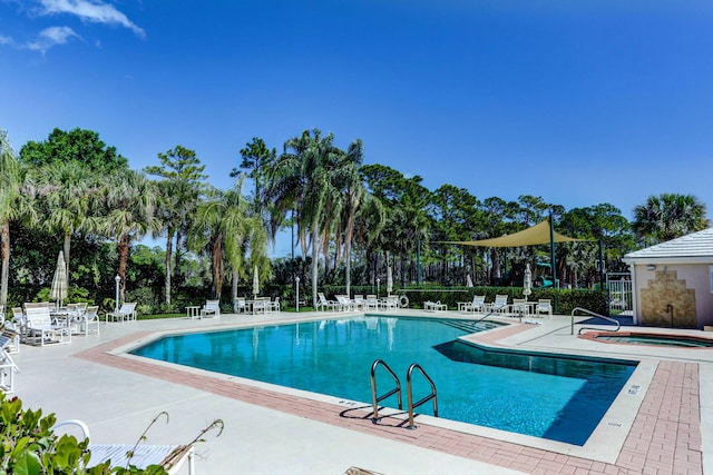 view of swimming pool with a hot tub and a patio