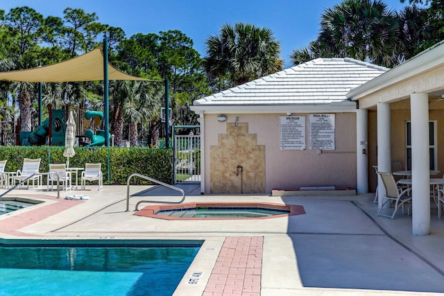 view of pool with a hot tub and a patio area