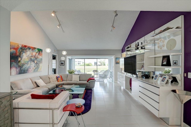 living room featuring high vaulted ceiling, rail lighting, a textured ceiling, and light tile patterned floors