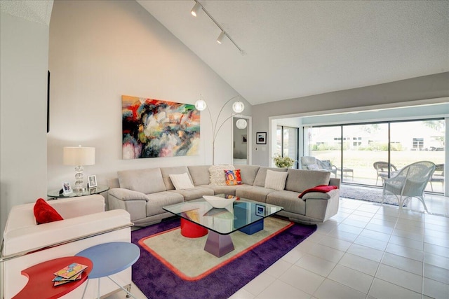 tiled living room with rail lighting, high vaulted ceiling, and a textured ceiling