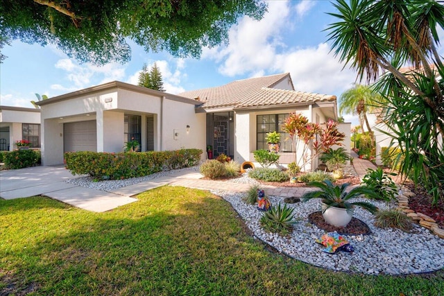 view of front of house featuring a tile roof, stucco siding, concrete driveway, a front yard, and a garage