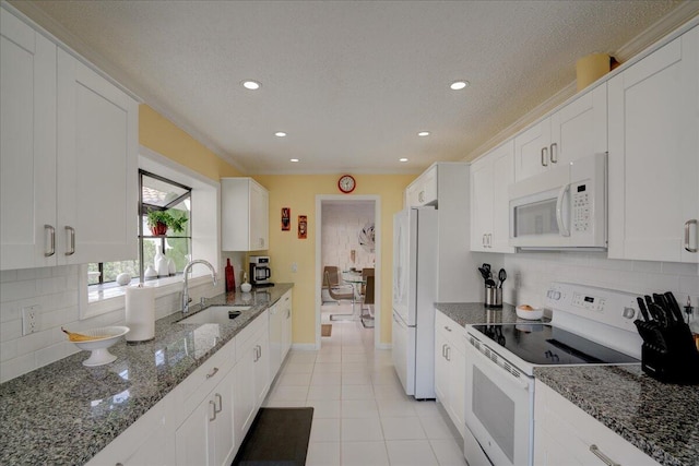 kitchen featuring white appliances, a sink, and white cabinetry