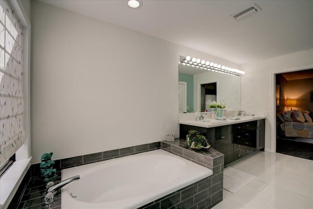 bathroom featuring connected bathroom, a sink, visible vents, a bath, and double vanity