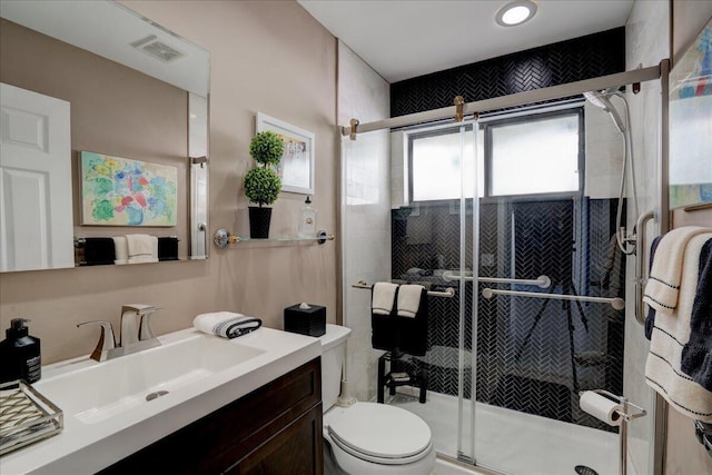 bathroom featuring visible vents, vanity, a shower stall, and toilet