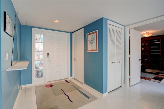 foyer with recessed lighting, tile patterned floors, and baseboards