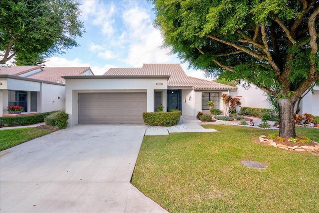 view of front of house featuring stucco siding, concrete driveway, a garage, a tiled roof, and a front lawn