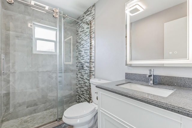 bathroom featuring a shower with shower door, vanity, and toilet